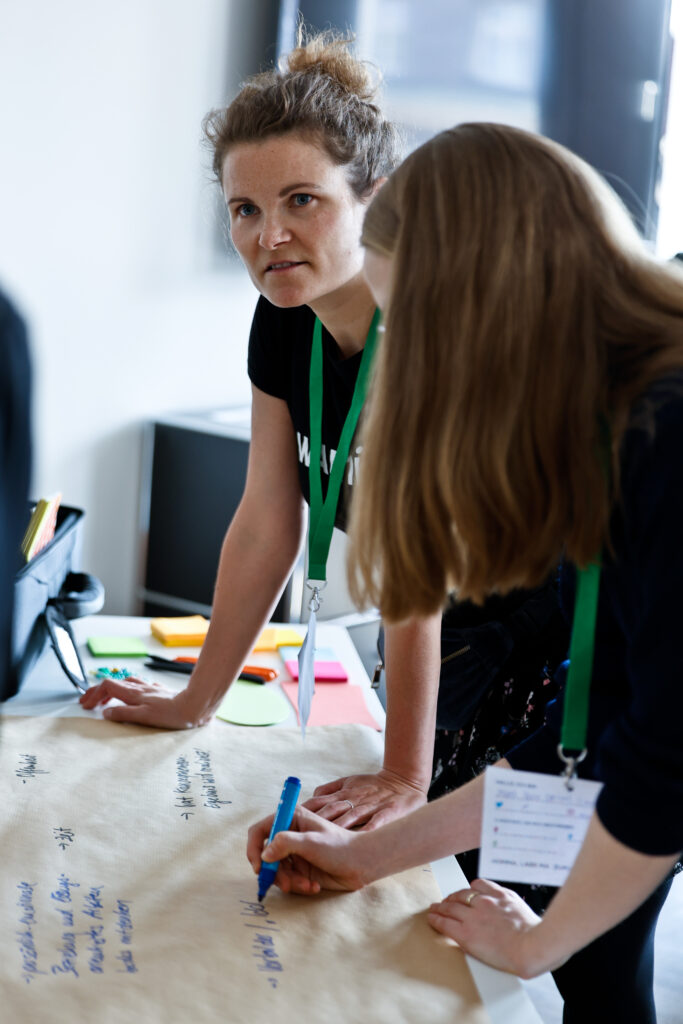 2 Personen schreiben auf Packpapier