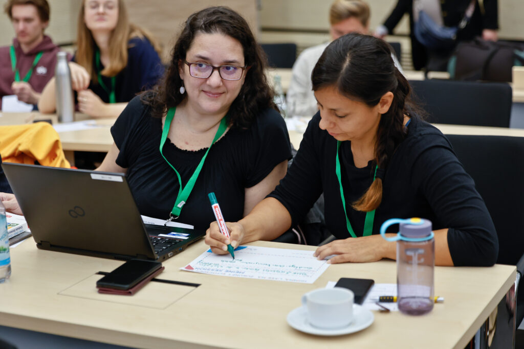 Sessionvorschlag im Zwiegespräch, zwei Frauen, eine mit Laptop, die andere füllt den Sessionvorschlag aus